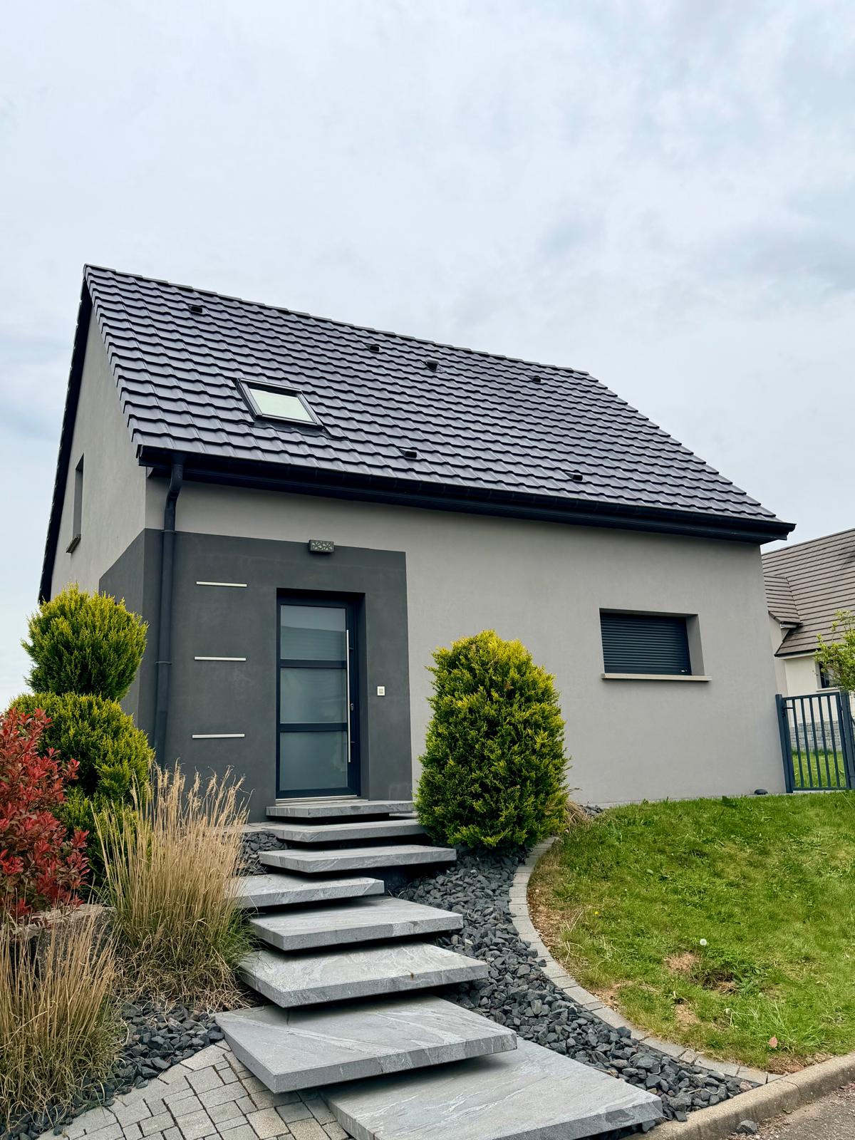 Traitement toiture maison grise — tuiles noires